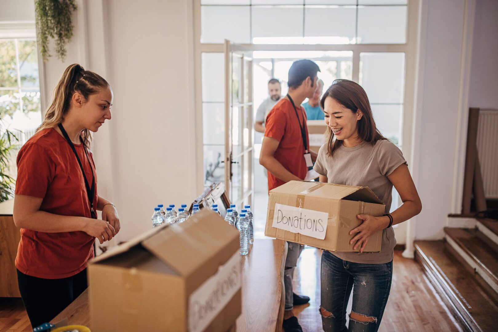 Woman donating box at charity event.