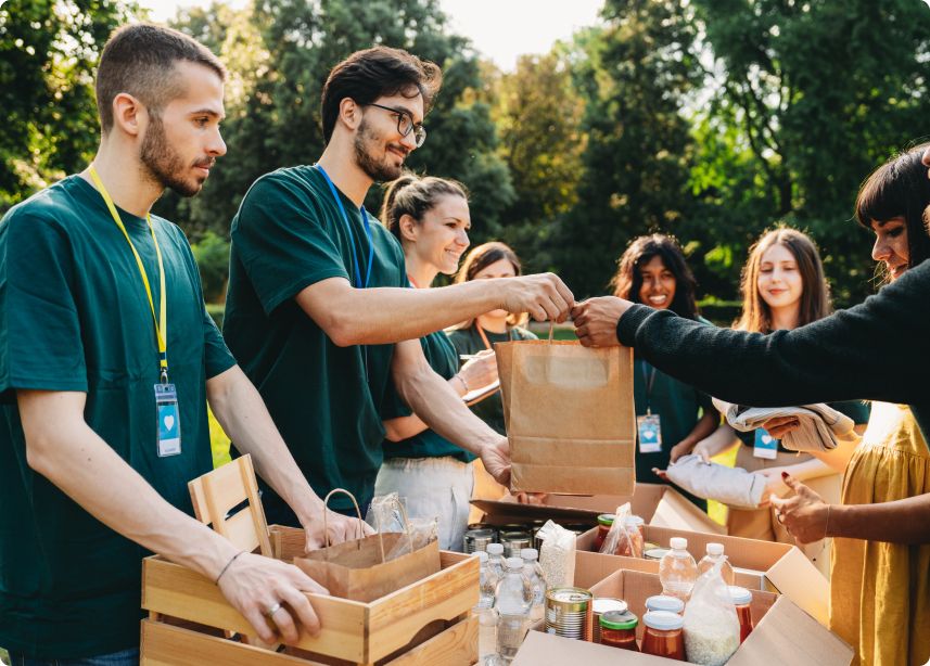 Volunteers distributing food at outdoor event.
